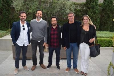 Five people standing outside; a mix of casual and business attire; smiling.