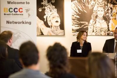 Panel discussion at BCCC networking event, California. Woman at podium, audience in foreground.