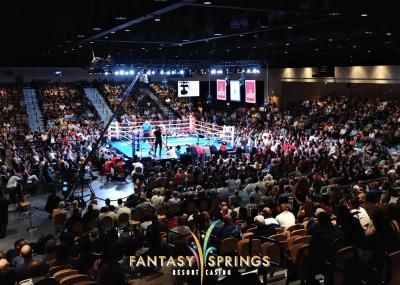 Boxing match at Fantasy Springs Resort, crowd watches ring with boxers.