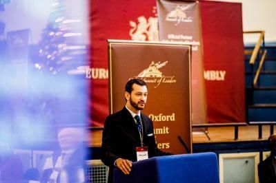 Man in suit speaking at podium with 