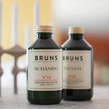 Twee flessen BRUNS shampoo op een aanrecht, één scherp in beeld en één wazig op de achtergrond.