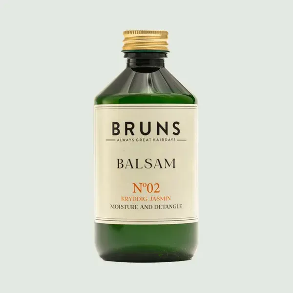 Groene glazen fles BRUNS Balsam N°02 met crèmekleurig etiket en gouden dop op een lichte achtergrond.