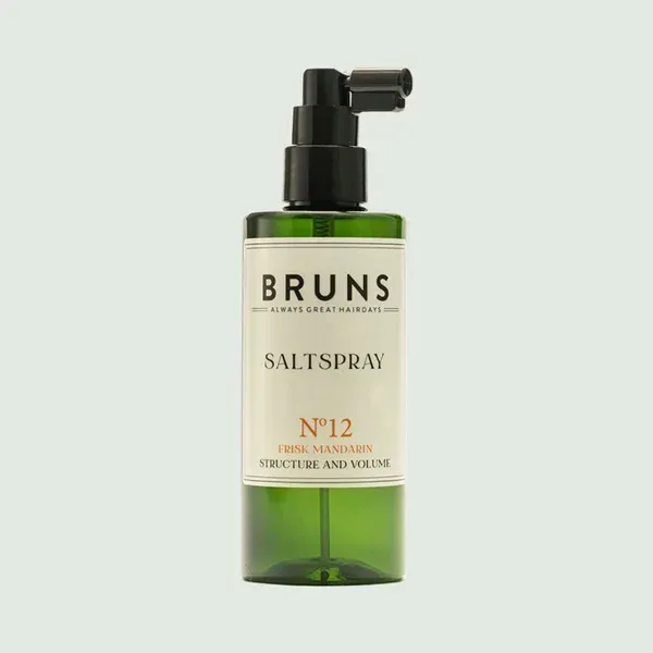 Bruns zoutsprayfles met groene vloeistof en zwarte pomp op een lichte achtergrond
