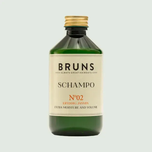 Groene BRUNS shampoofles met crèmekleurig etiket en gouden dop, met de opschriften “No.2” en “Extra Moisture and Volume”.