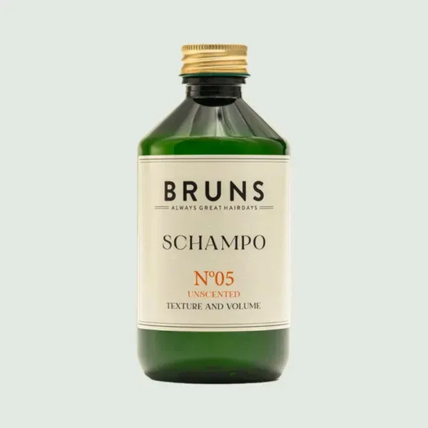 Groene Bruns Champo fles met gouden dop en crèmekleurig etiket op een lichtgekleurde achtergrond.
