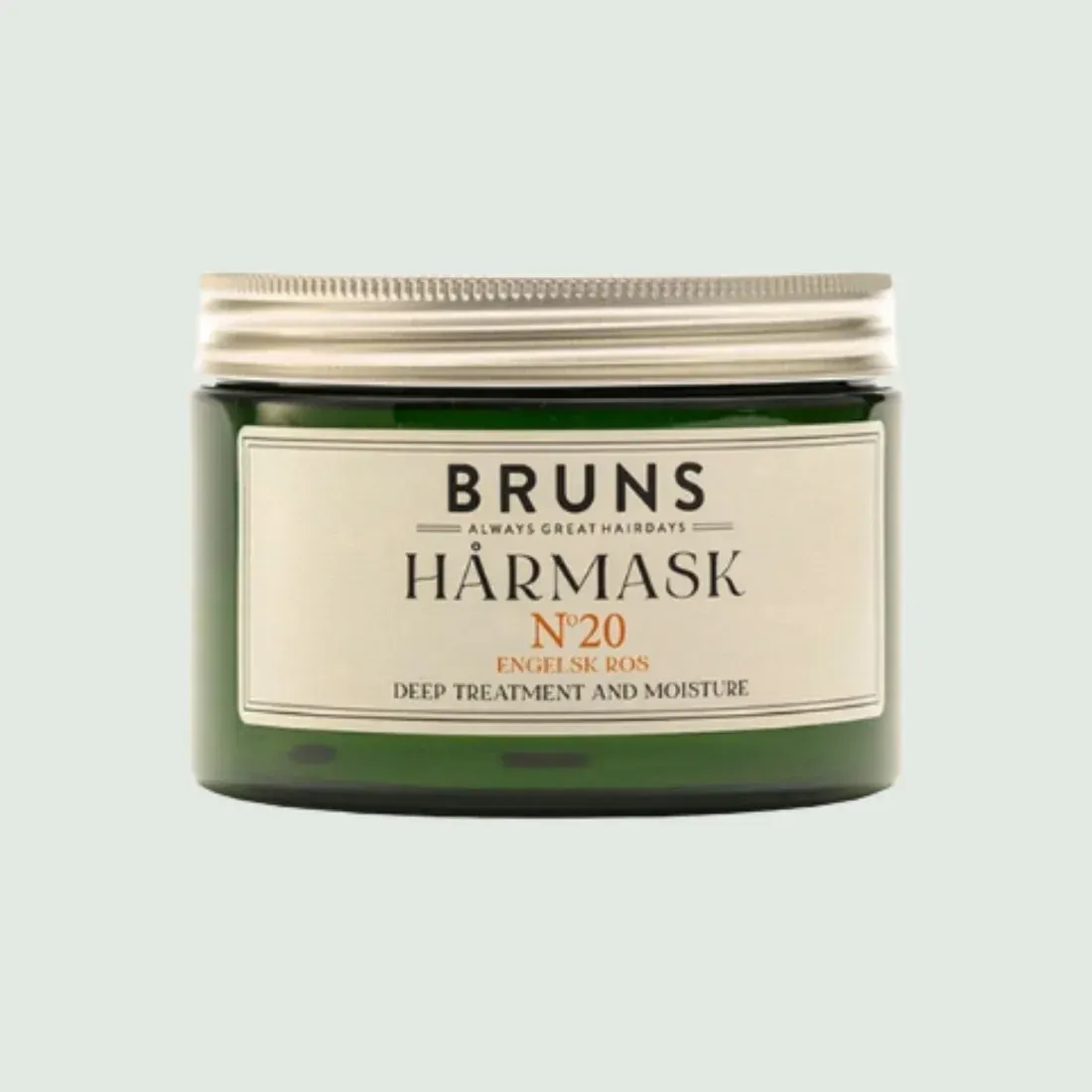 Bruns Hårmask N°20 in een donkergroene pot met een beige etiket op een lichte achtergrond.