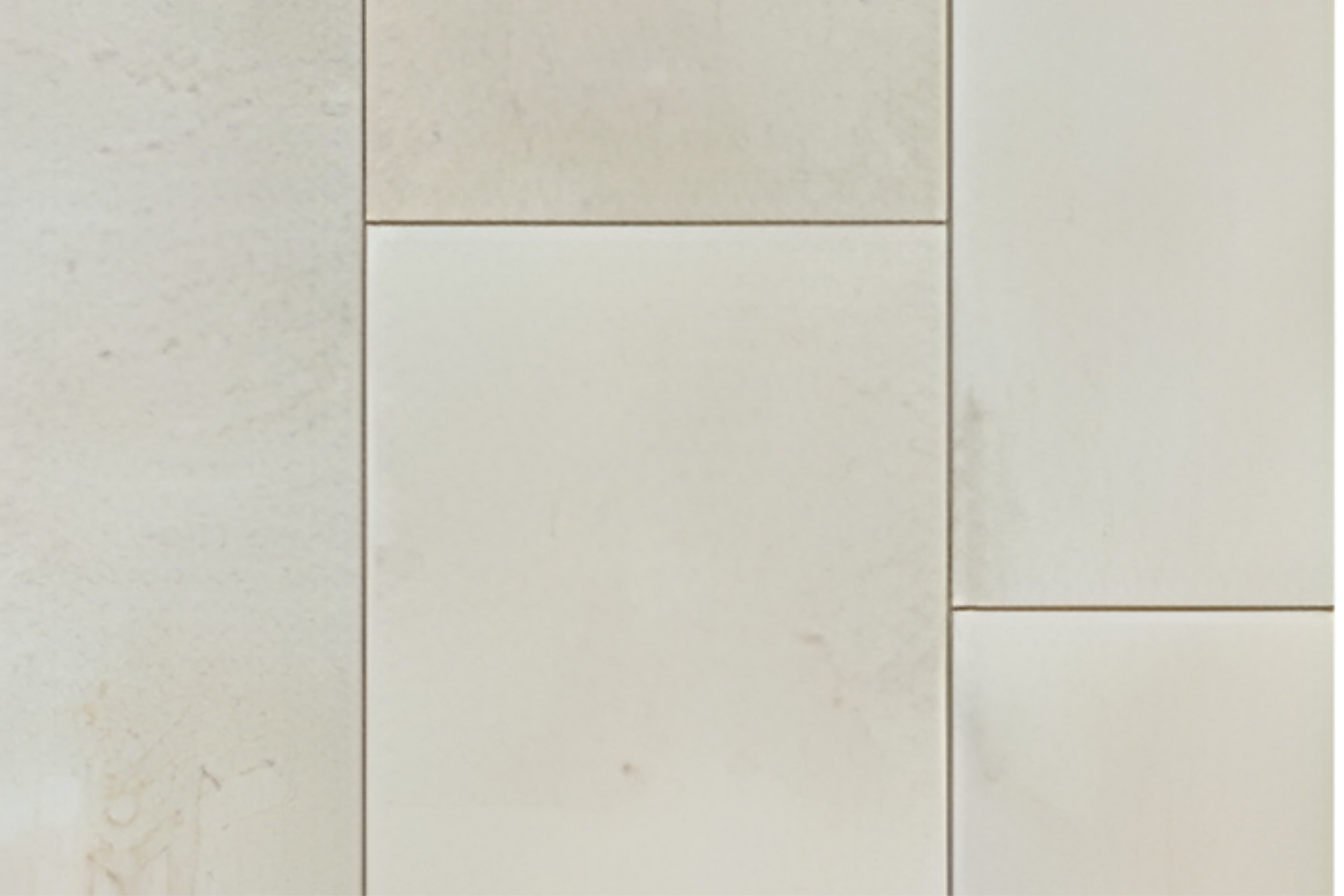 Abstract arrangement of cream-colored rectangular wall panels with thin brown seams