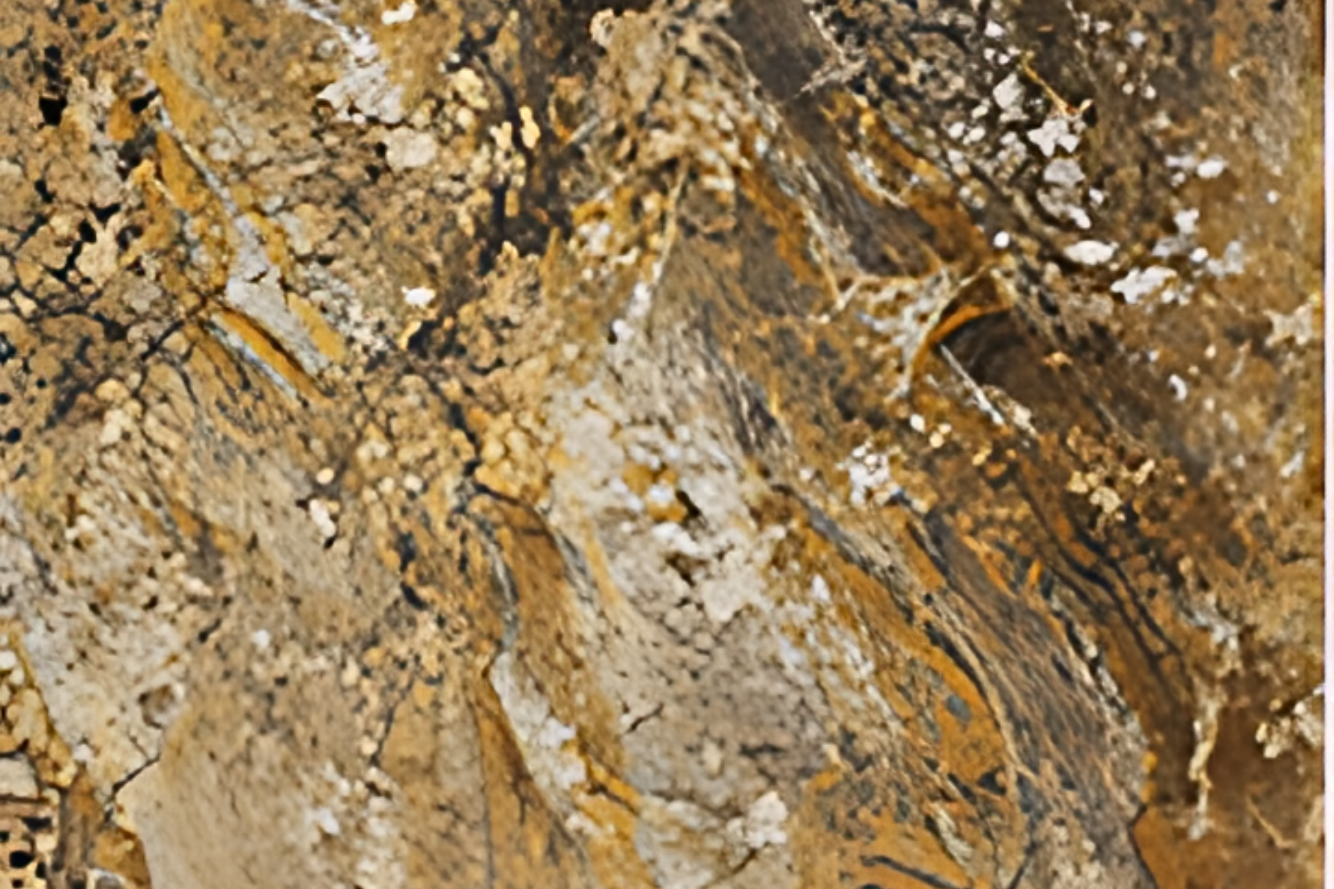 Close-up of rough brown, tan, and gray rock with layered, cracked texture