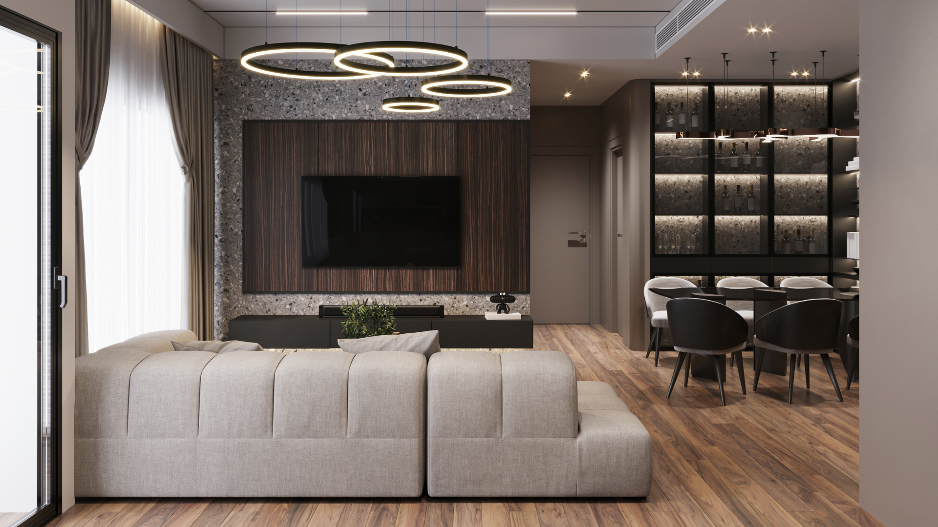 Modern living room with gray sofa, wall-mounted TV, ring ceiling lights, and dining area.