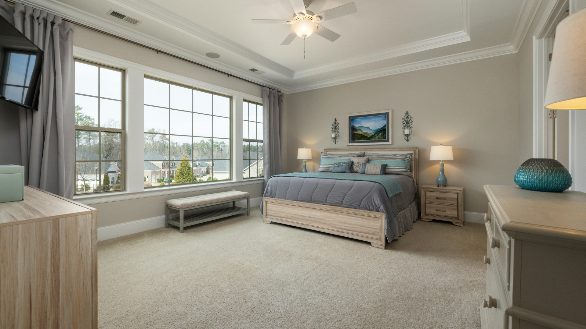 Bright coastal bedroom with large windows, a bed, bench, and sea view