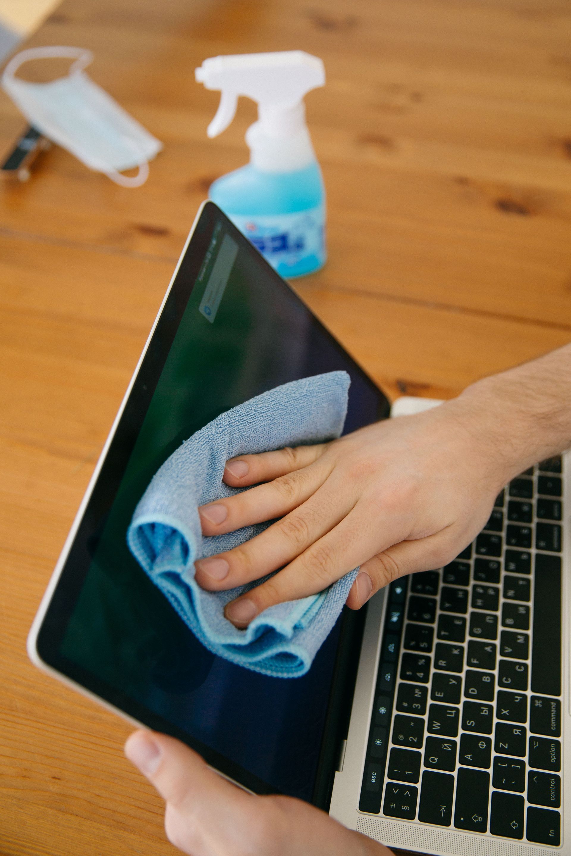 Person wiping down an office desk during a professional clean