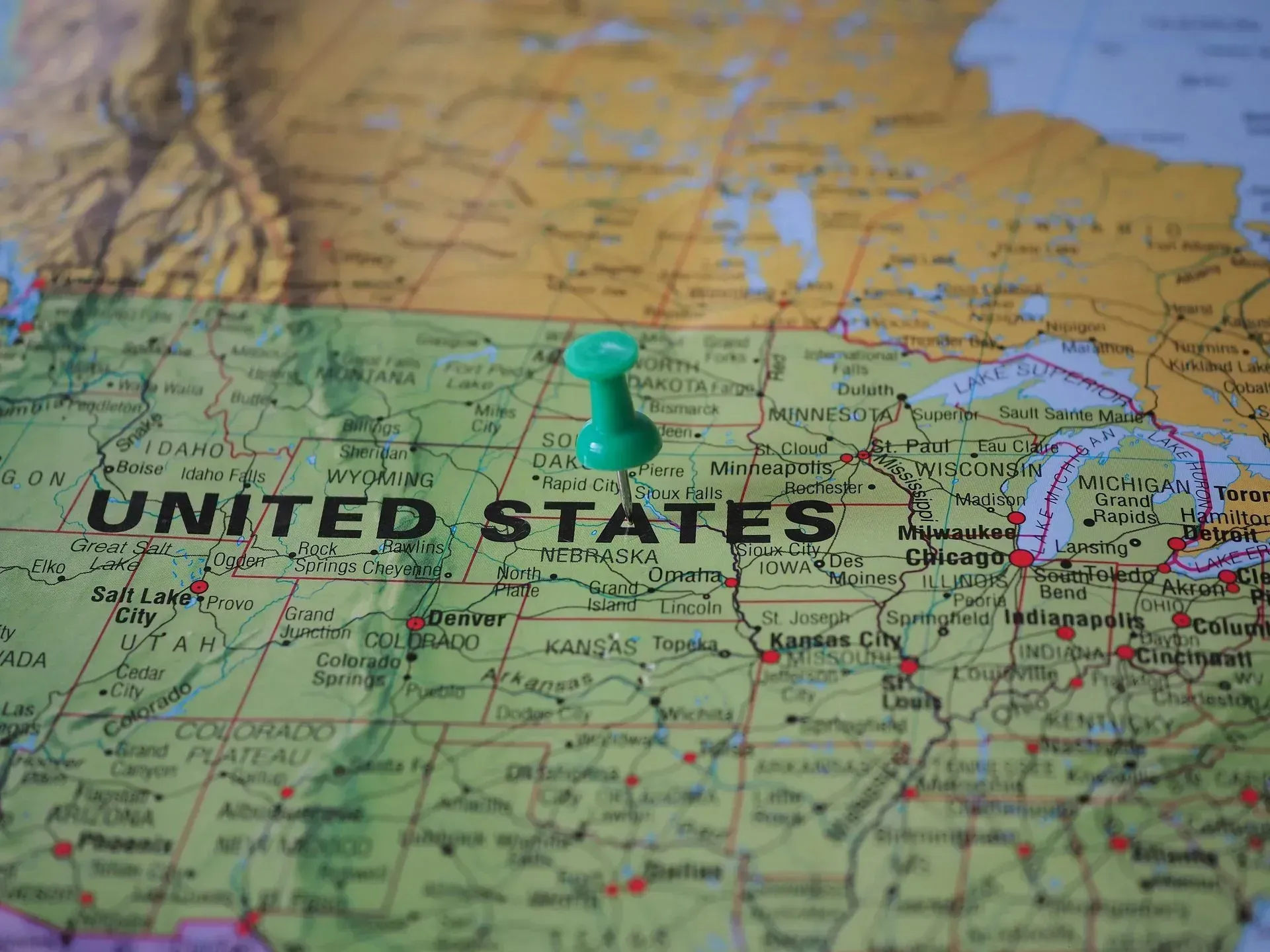 Green pushpin on a map of the United States and Great Lakes region