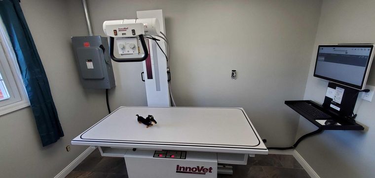 Hospital CT scanner room with patient table and computer monitor
