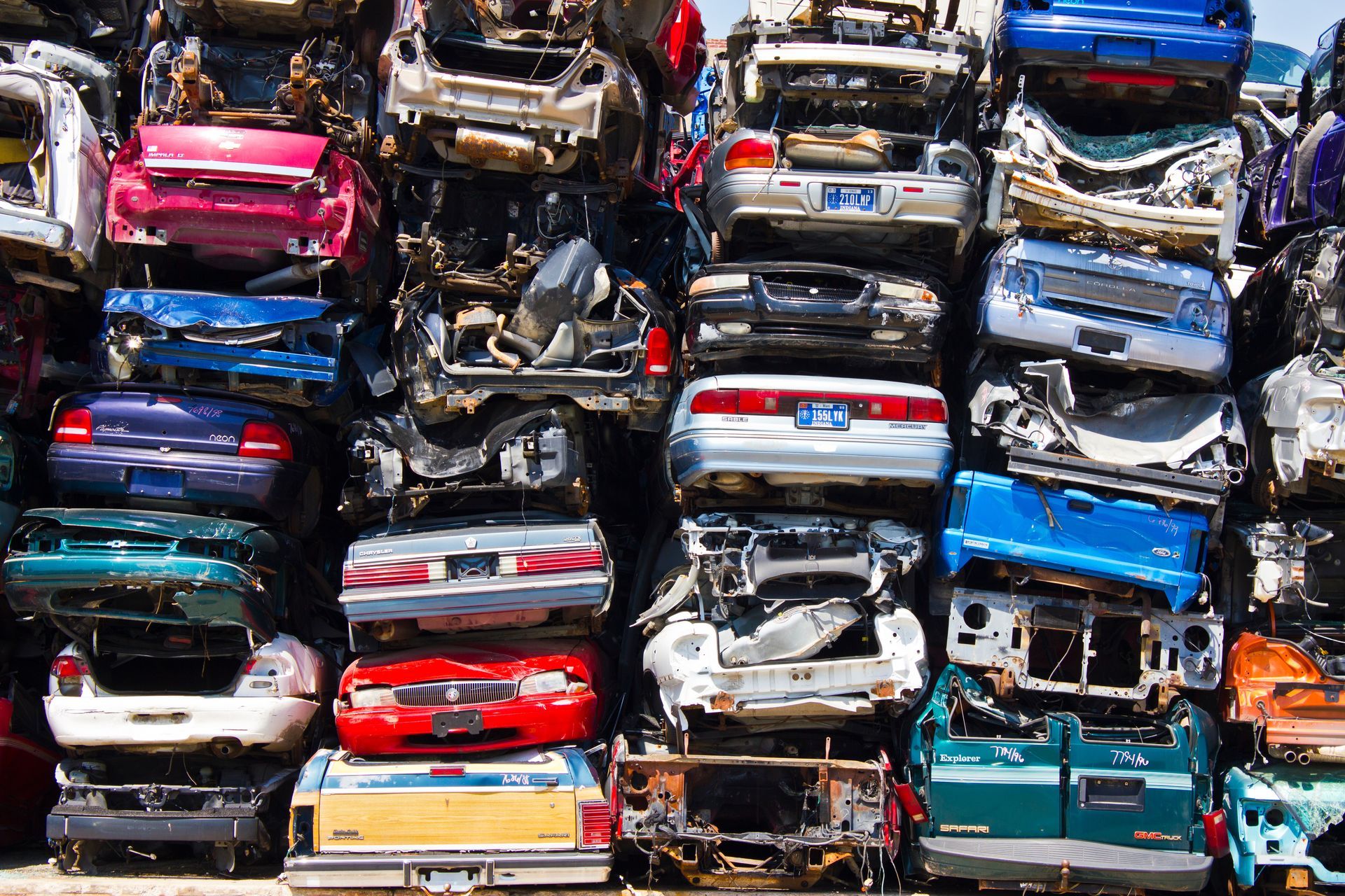 Junk vehicles collected and organized inside a busy auto wrecking scrap yard.