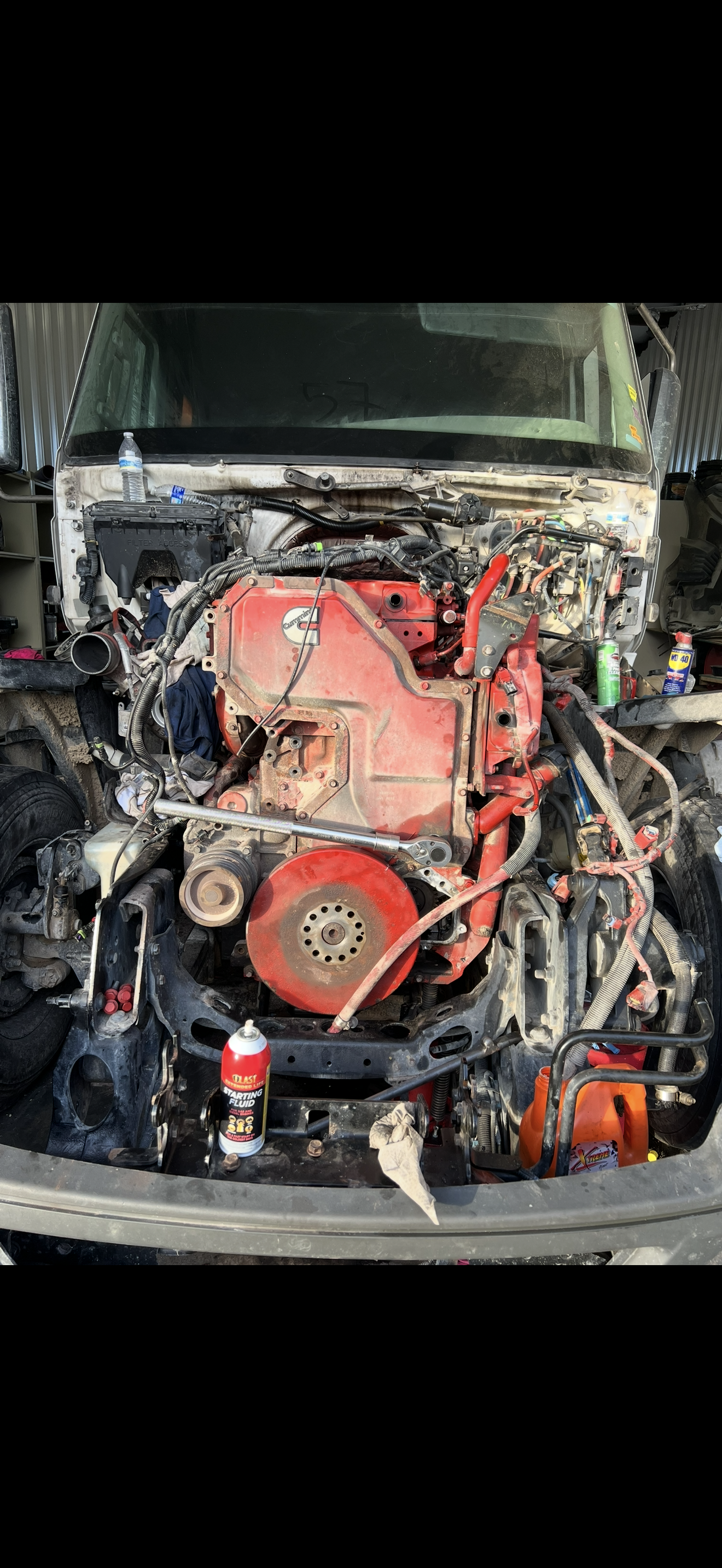 A red engine of a vehicle is on display. It's in a mechanical setting.