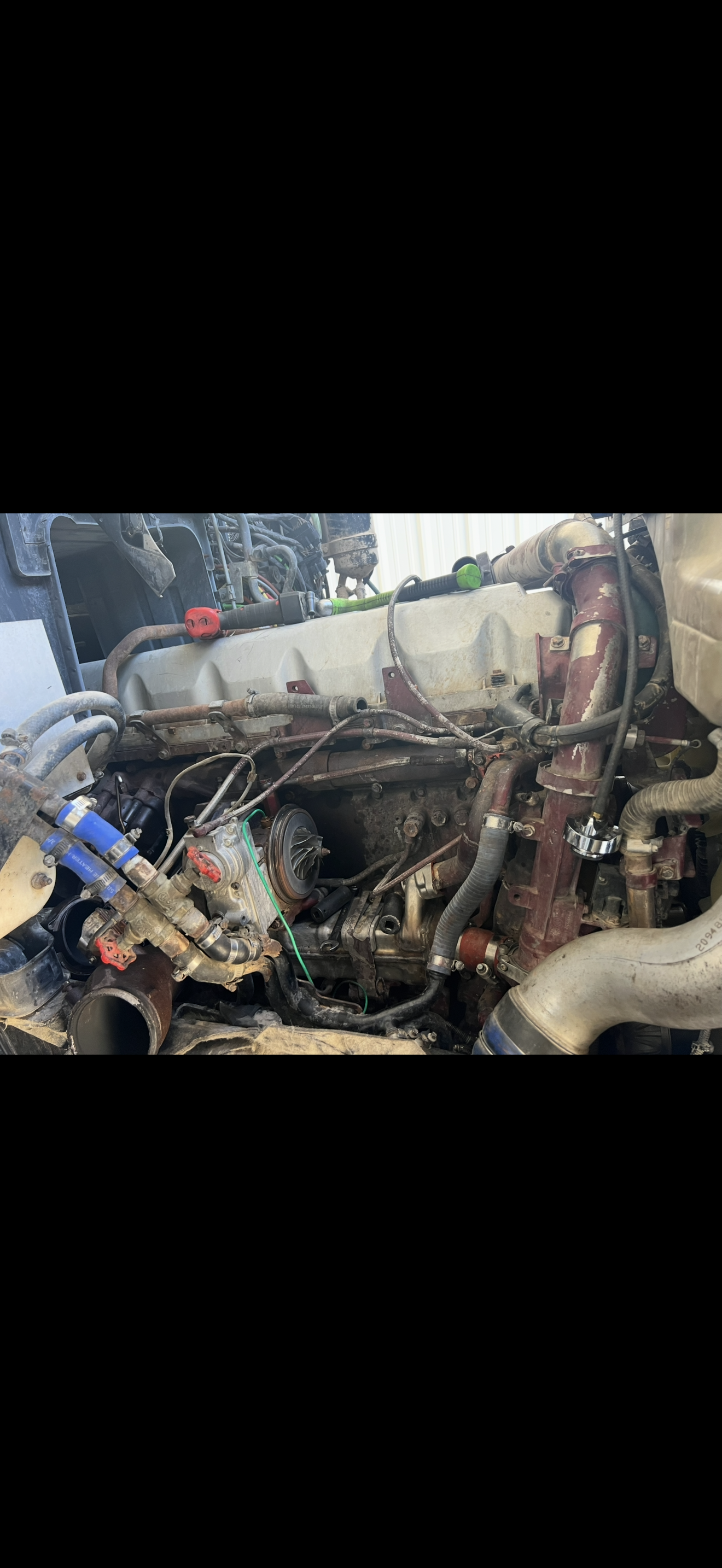 Close-up view of a truck engine with various components and hoses.