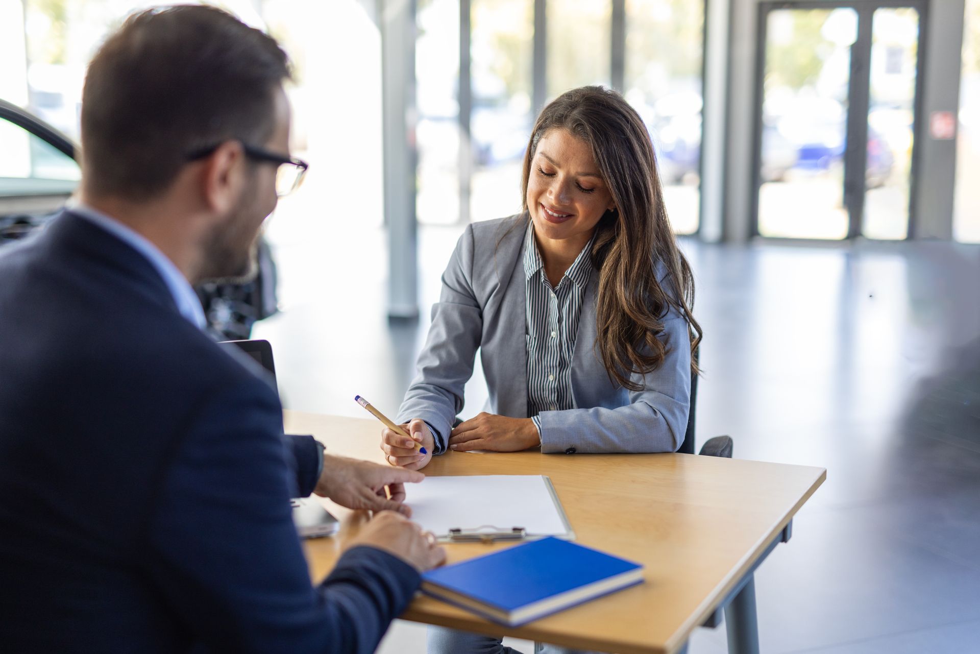A woman is signing a car insurance document.