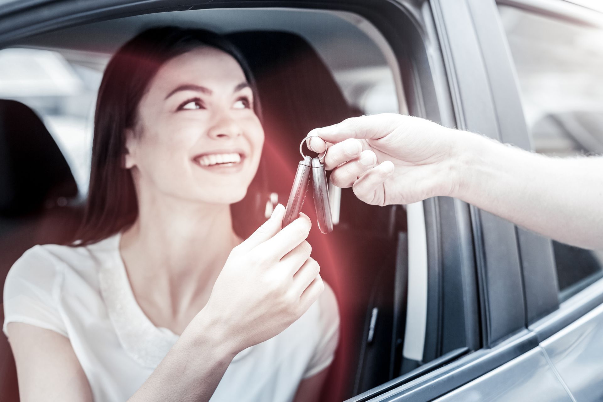 Extremely happy young lady grinning broadly while sitting in her automobile. Extremely happy young lady grinning broadly while sitting in her automobile.