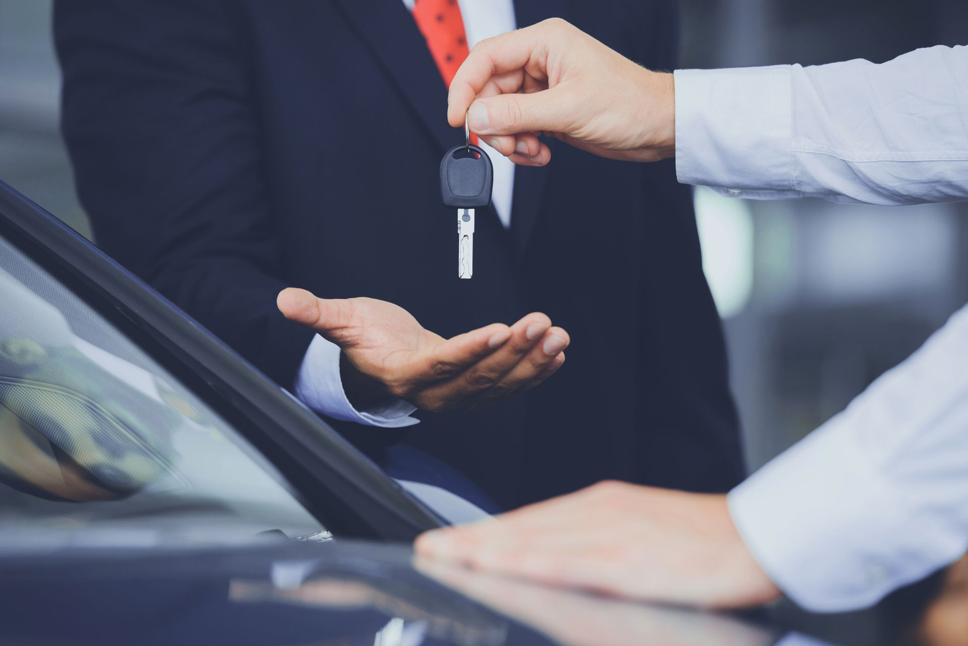 Close up of dealer giving key to new owner. Close up of dealer giving key to new owner.