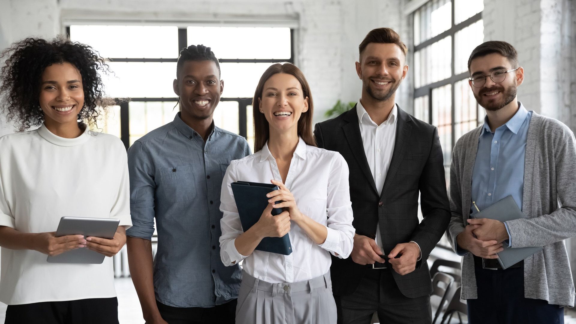 A group of business people are posing for a picture in an office.