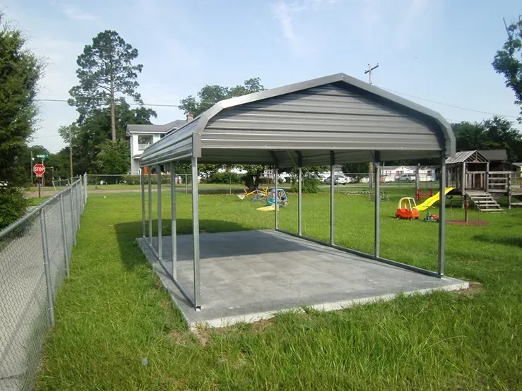 a carport in a park with a stop sign in the background
