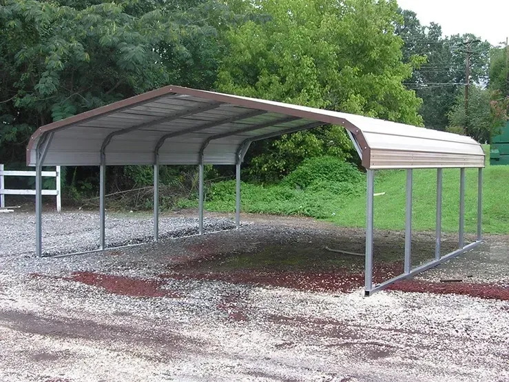 a metal carport in a gravel area with trees in the background