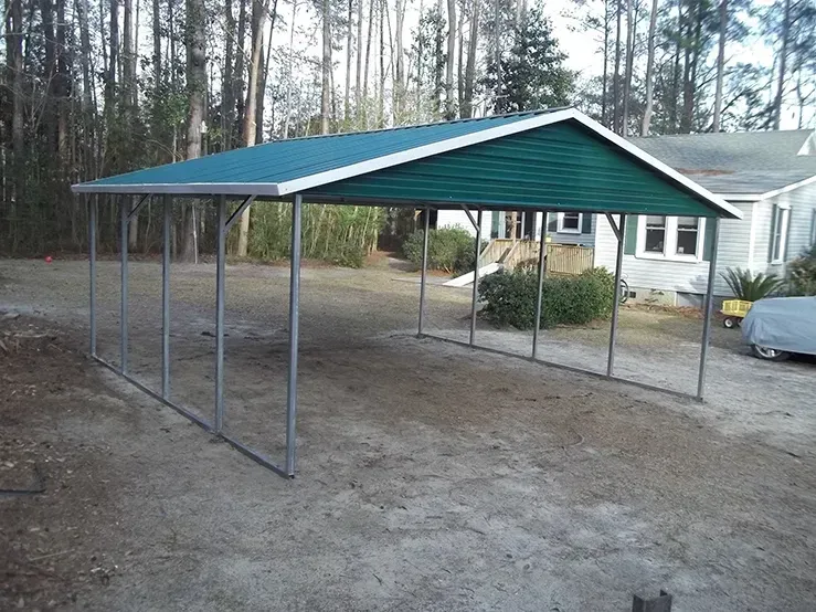 A carport with a green roof is in front of a house