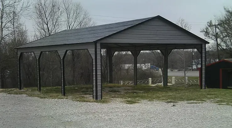a carport is sitting in the middle of a gravel road