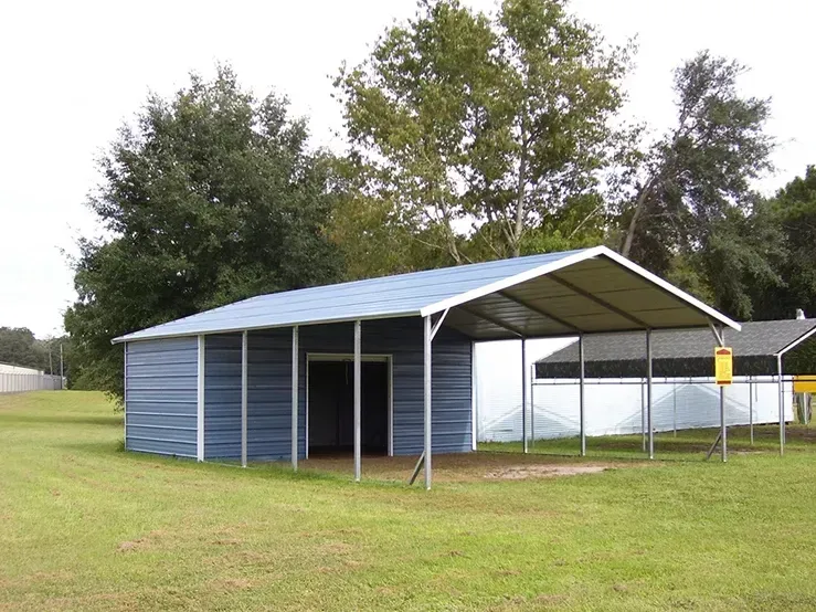 A blue building with a white roof is in the middle of a grassy field