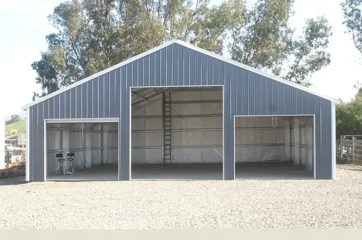 A large metal building with two garage doors and a ladder.