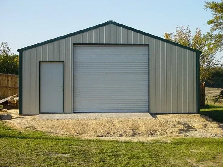 A metal garage with a white door and a green roof