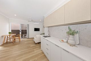 Kitchenette in a finished rooming house suite, with sink, fridge and overhead cupboards