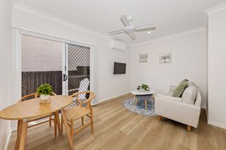Living and dining space in a finished rooming house suite, with sofa and dining table