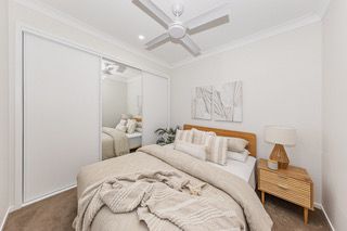 Bedroom in a finished rooming house suite, with a double bed and built-in robe