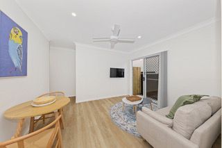 Living and dining space in a finished rooming house suite, with sofa and dining table