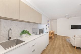 Kitchenette in a finished rooming house suite, with sink, microwave and fridge