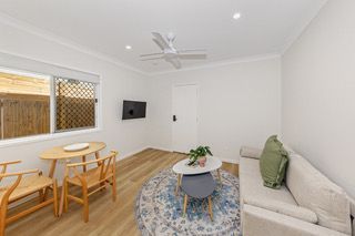 Living and dining space in a finished rooming house suite, with sofa and dining table