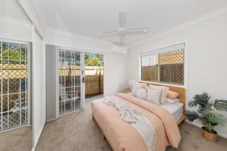 Bedroom in a finished rooming house suite, with a double bed and a window seat
