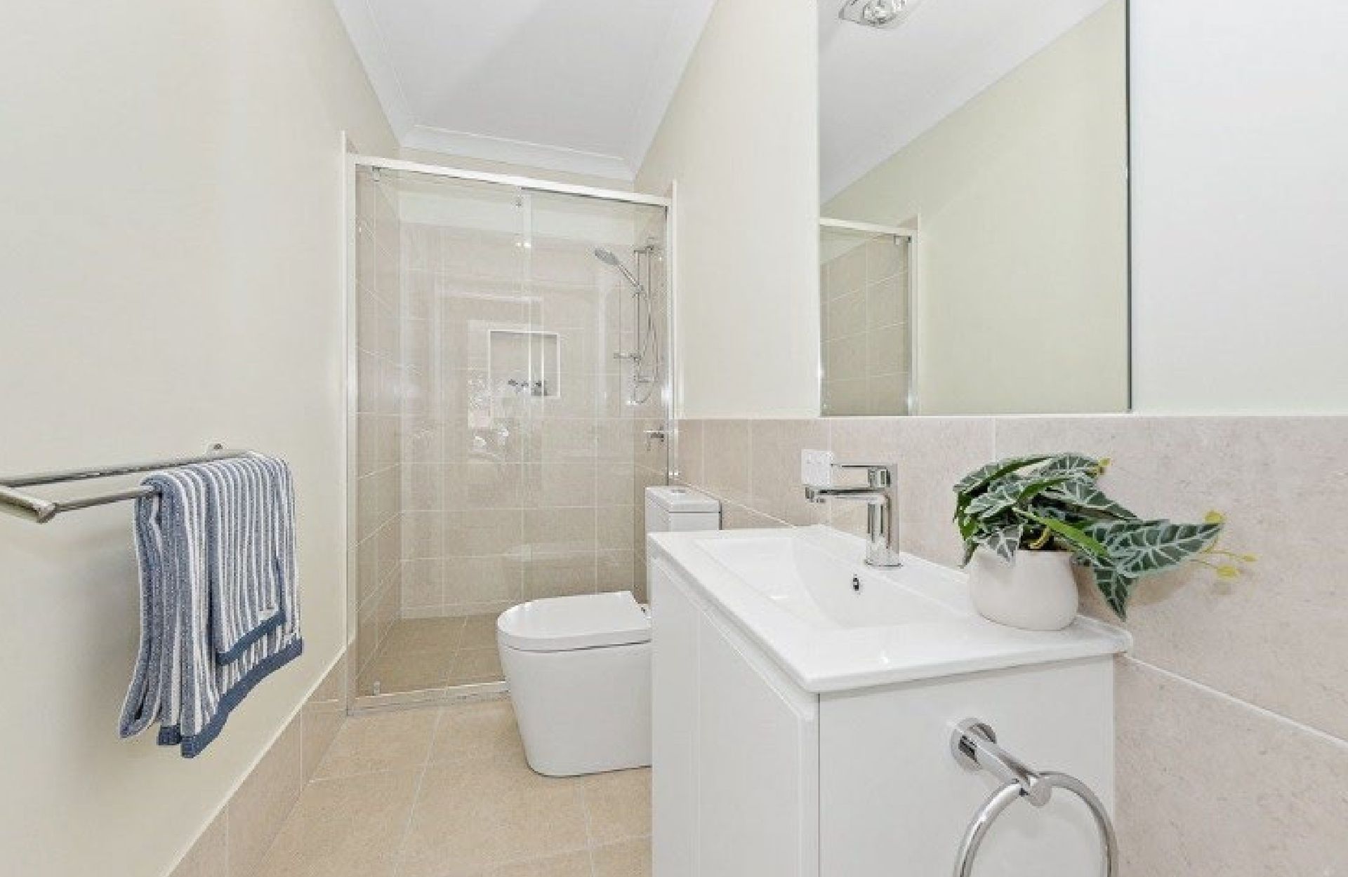 A finished bathroom with vanity, toilet and shower