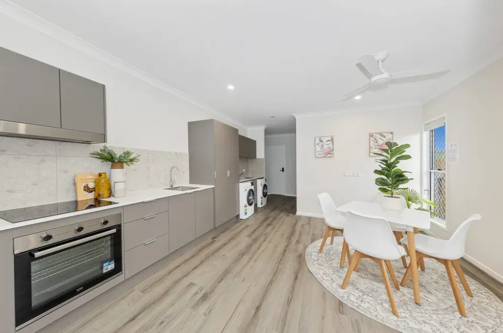 Kitchen with an oven, and a dining table and chairs beside it