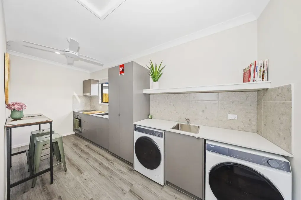 Kitchen with a washing machine and dryer beside the benchtop