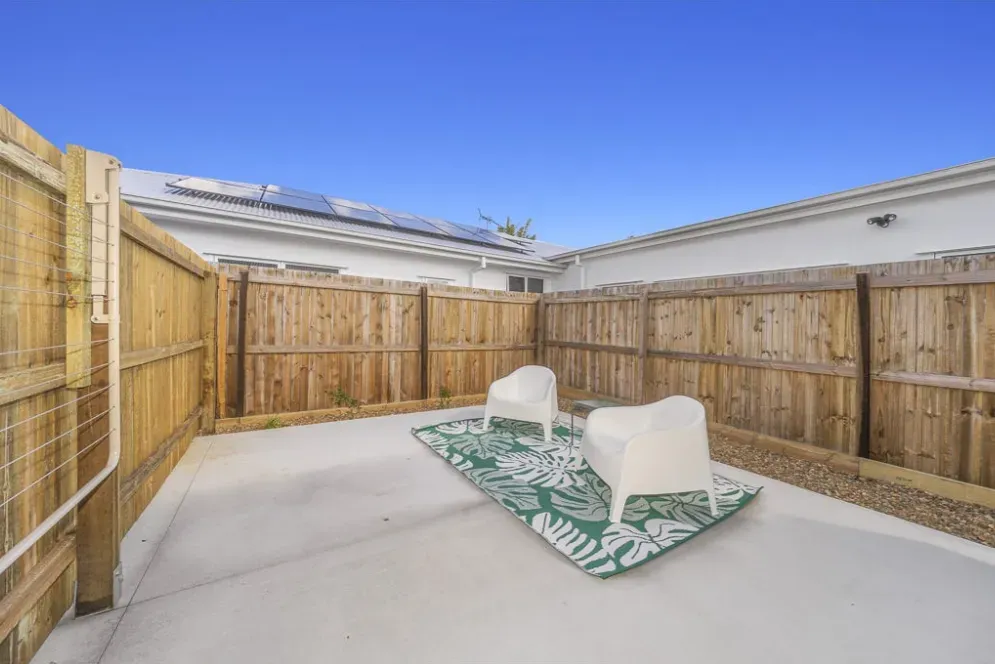 Private paved courtyard with a timber fence and outdoor seating