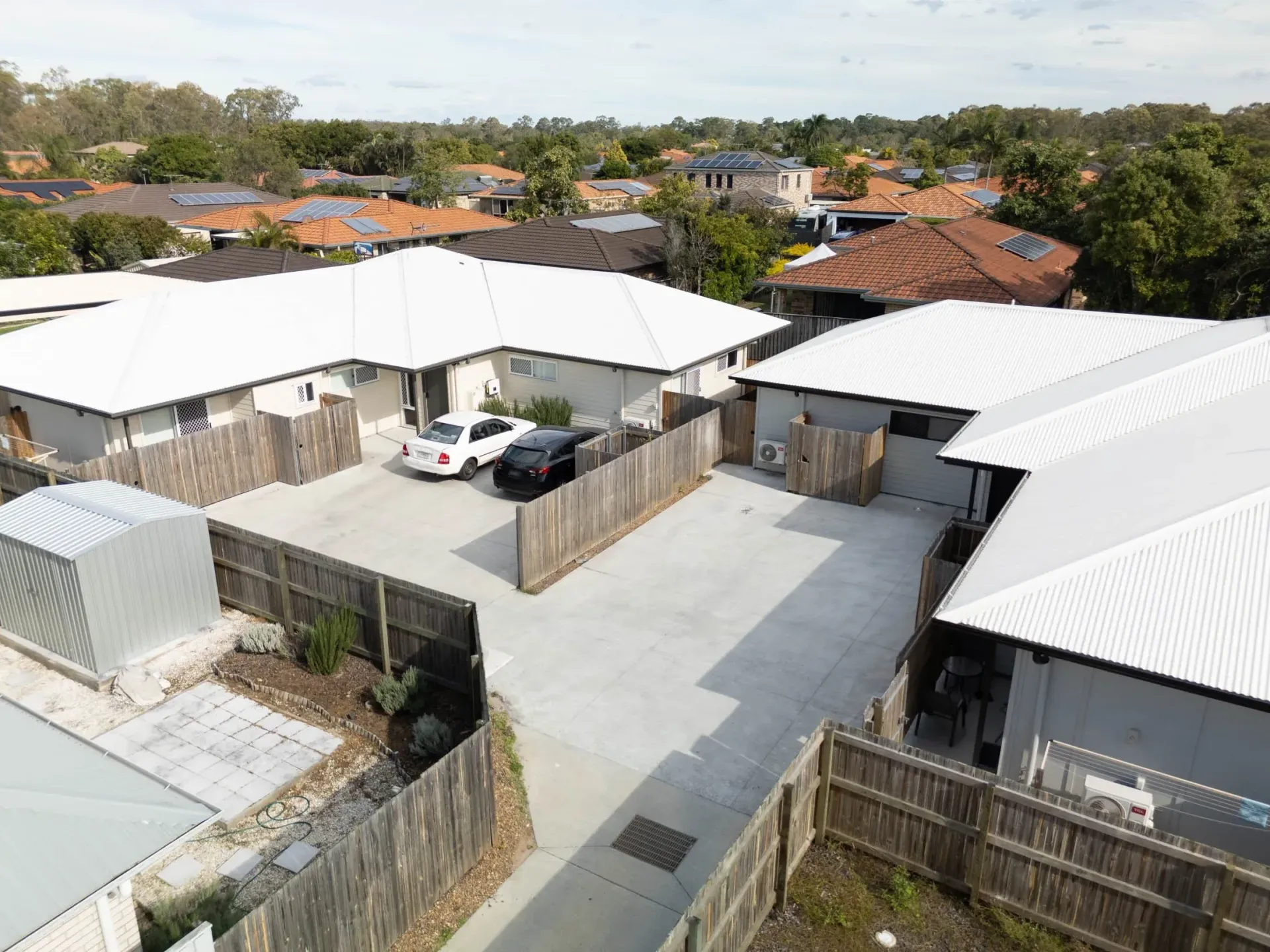 Driveway alongside a completed rooming house, with off-street parking