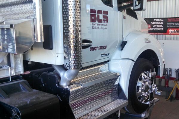 White semi-truck with chrome detailing being serviced.