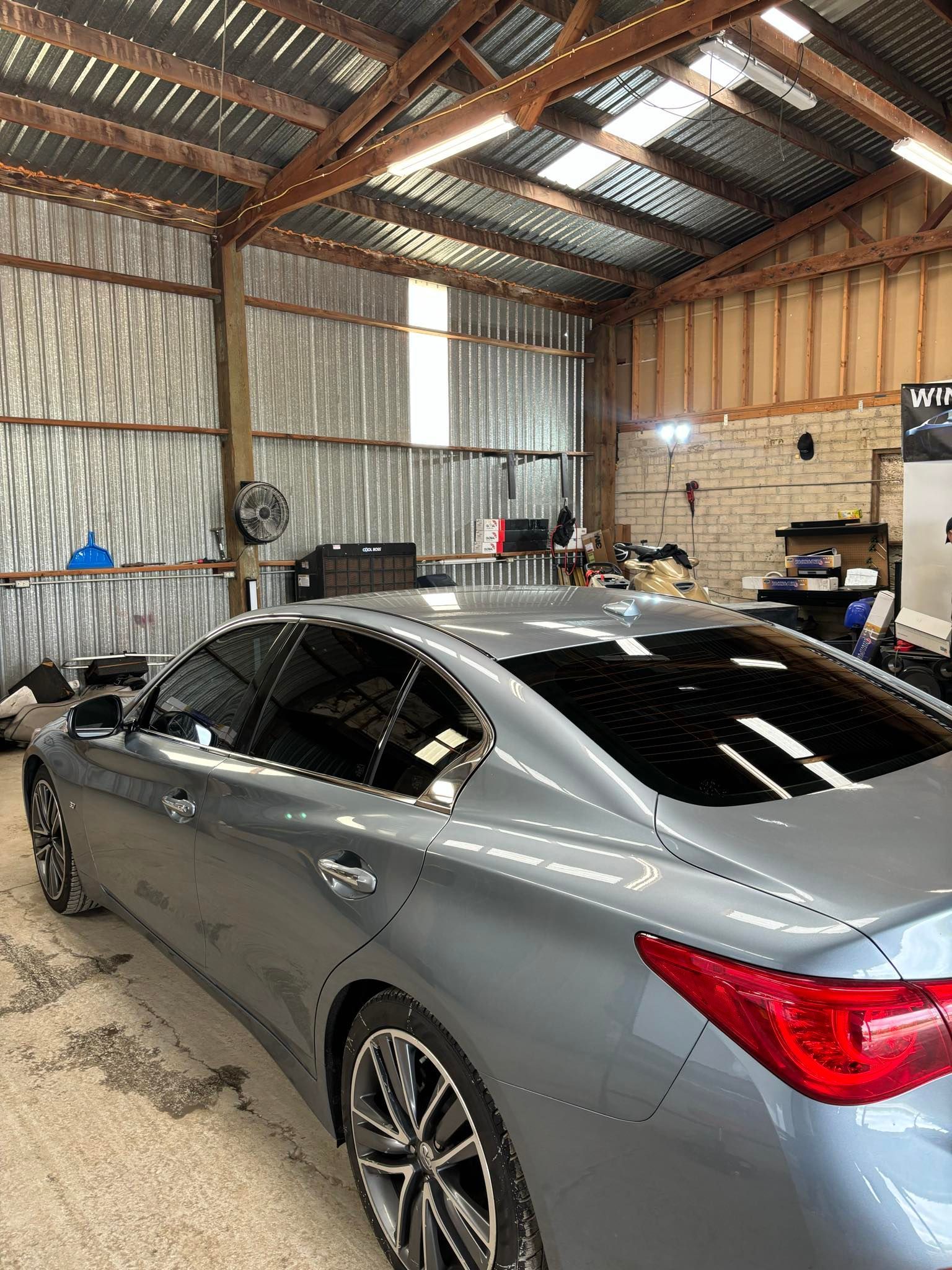 A white car is parked in front of a garage.