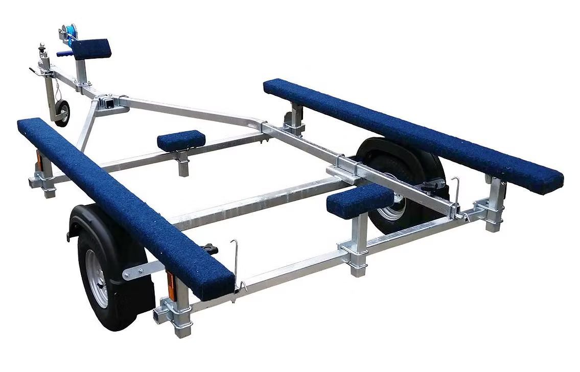 Boat trailer with blue padded rails, a winch, and wheels.