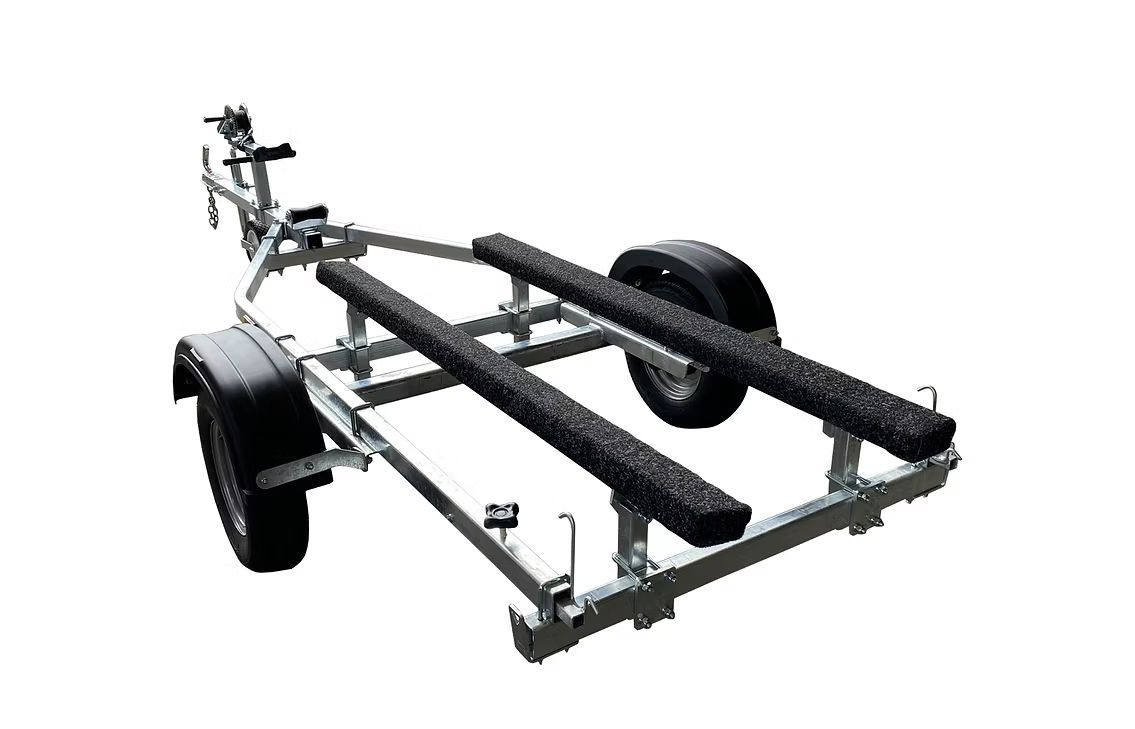 Boat trailer with blue carpeted bunks and a winch.