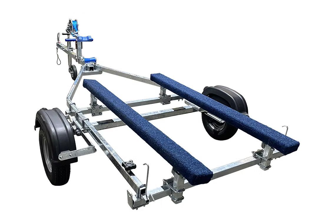 Boat trailer with blue carpeted bunks and a winch.