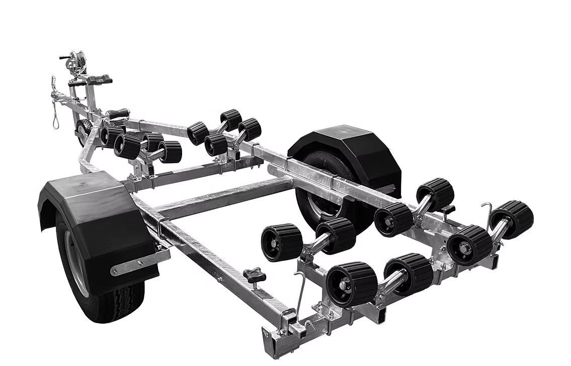 Boat trailer with blue rollers and black fender, outdoors.