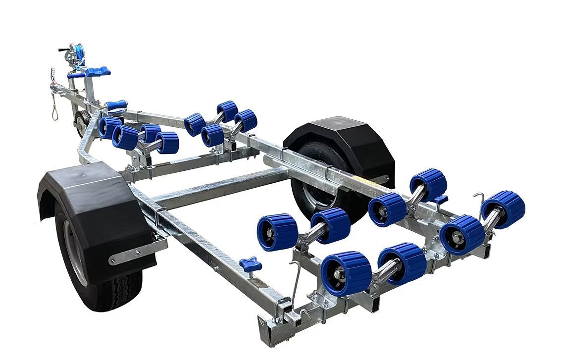 Boat trailer with blue rollers and black fender, outdoors.